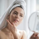 How should you care for your skin in autumn? A serene and elegant woman enjoys a skincare ritual, enhancing her natural beauty in the comfort of her home.